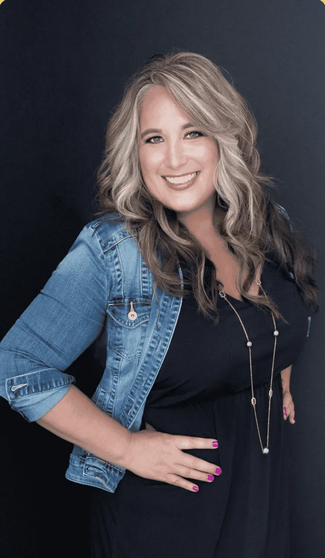 A coaching client smiling in a denim jacket